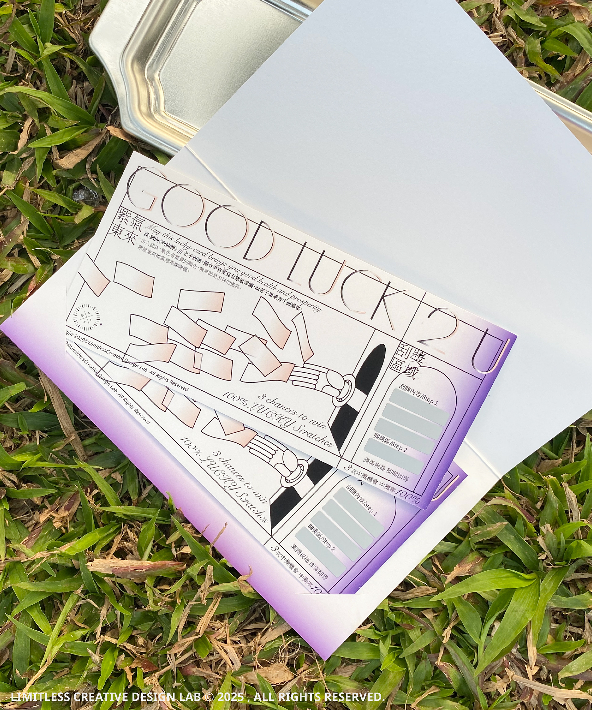 A Good Luck scratch card on white paper beside grass outdoors.