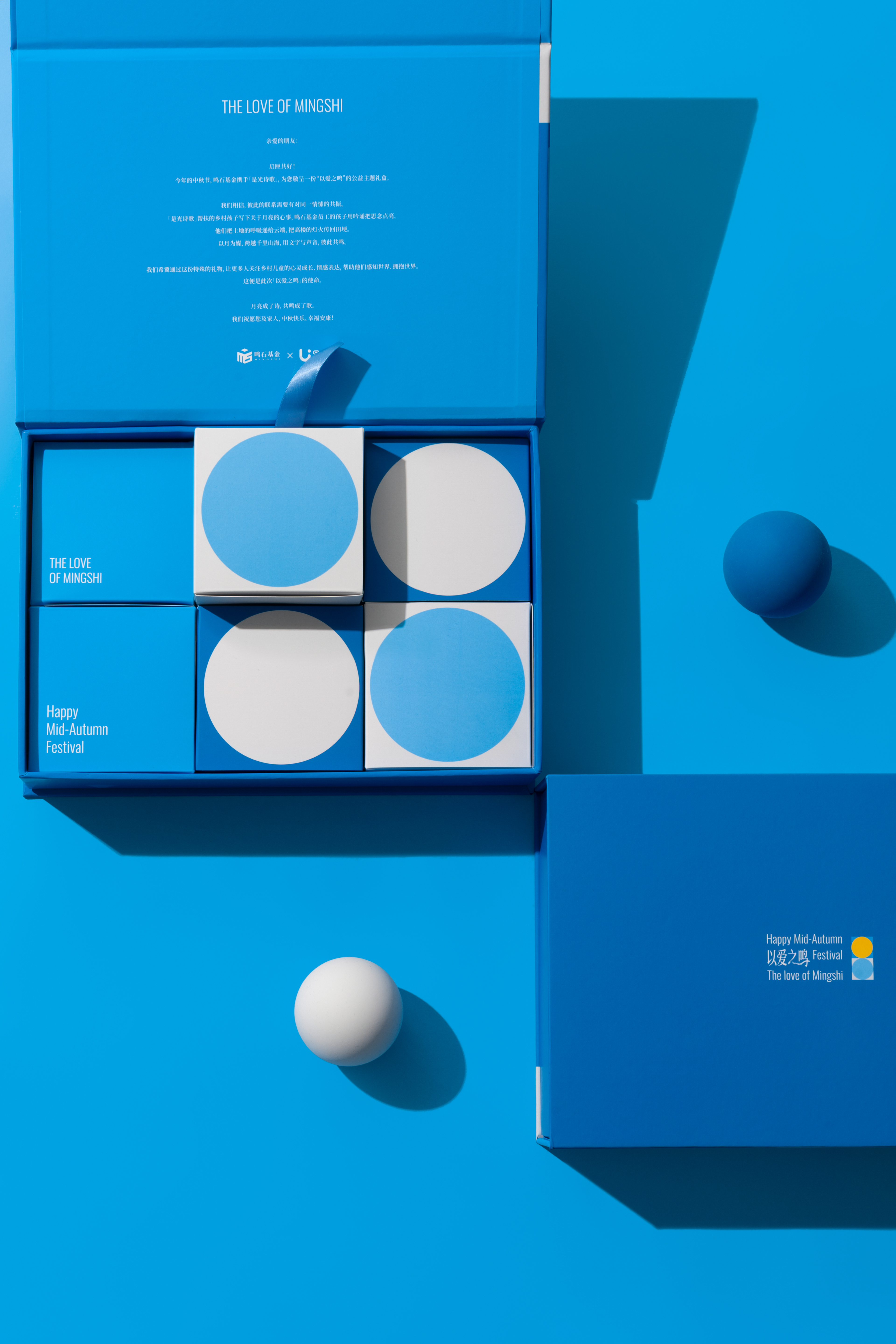 An open blue 2025 Mid-Autumn gift box containing four geometric packages.