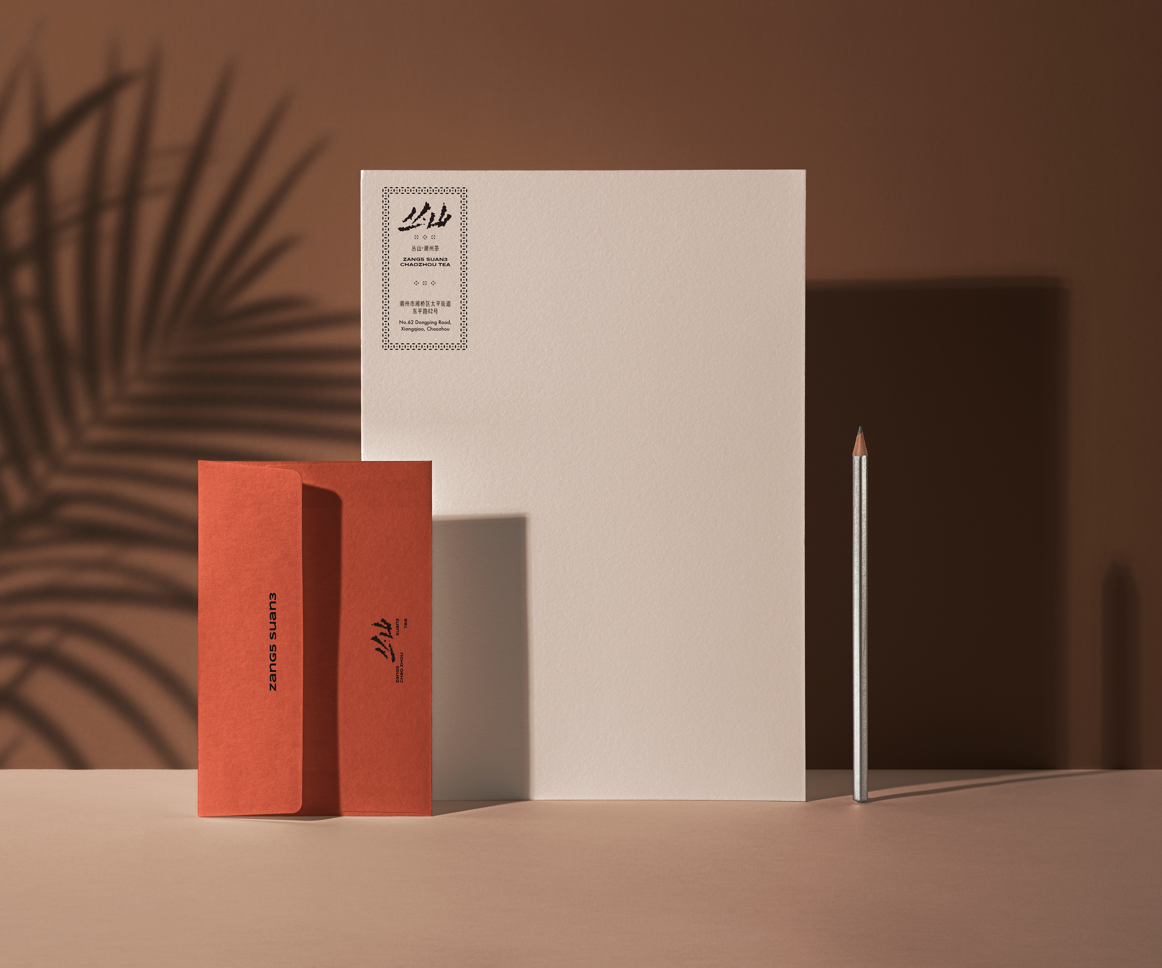 Red business cards, white stationery and a pencil for Zang5Suan3.